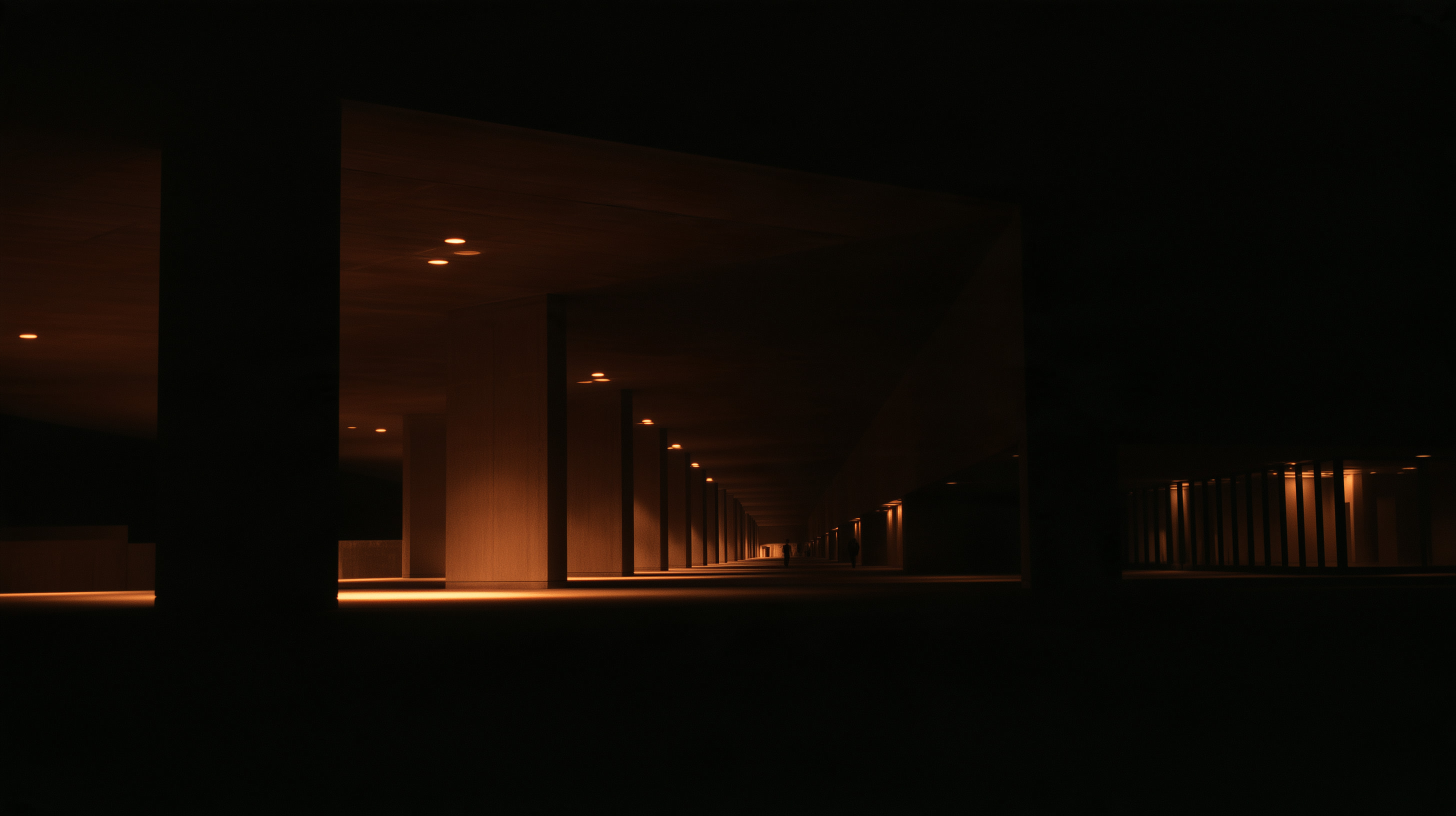 Dark colonnade lit by a line of warm downlights